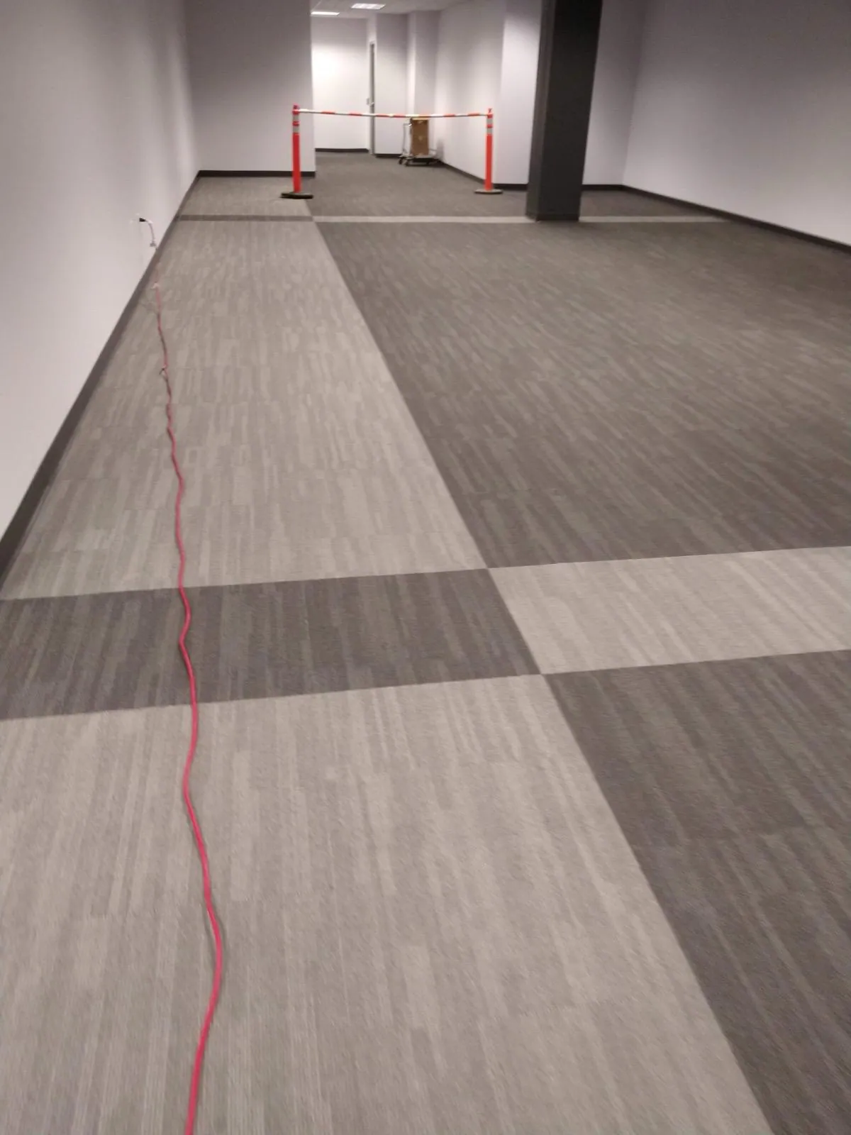 Large open office space with freshly laid gray carpet tile