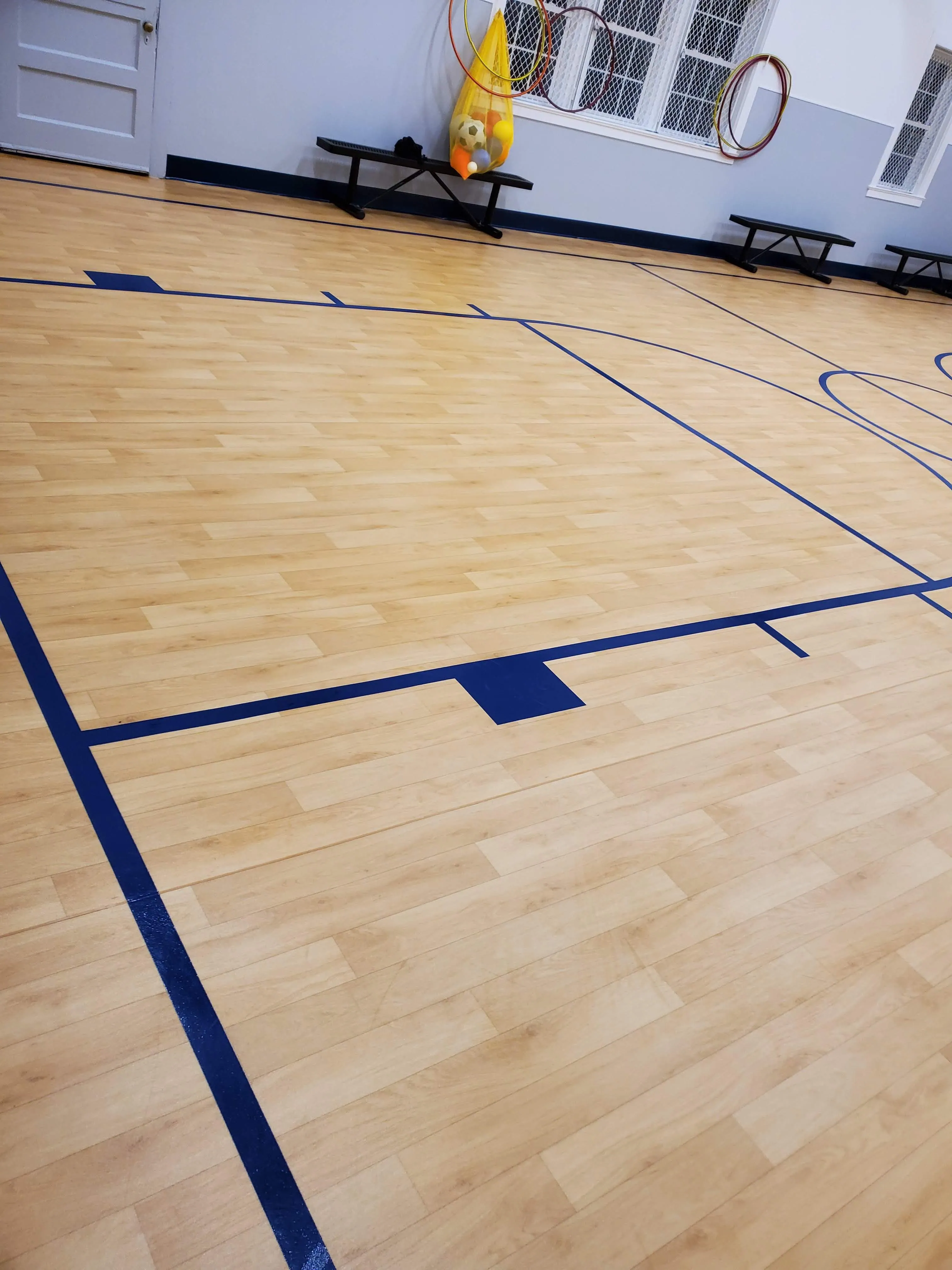 Gym floor with blue court lines after cleaning
